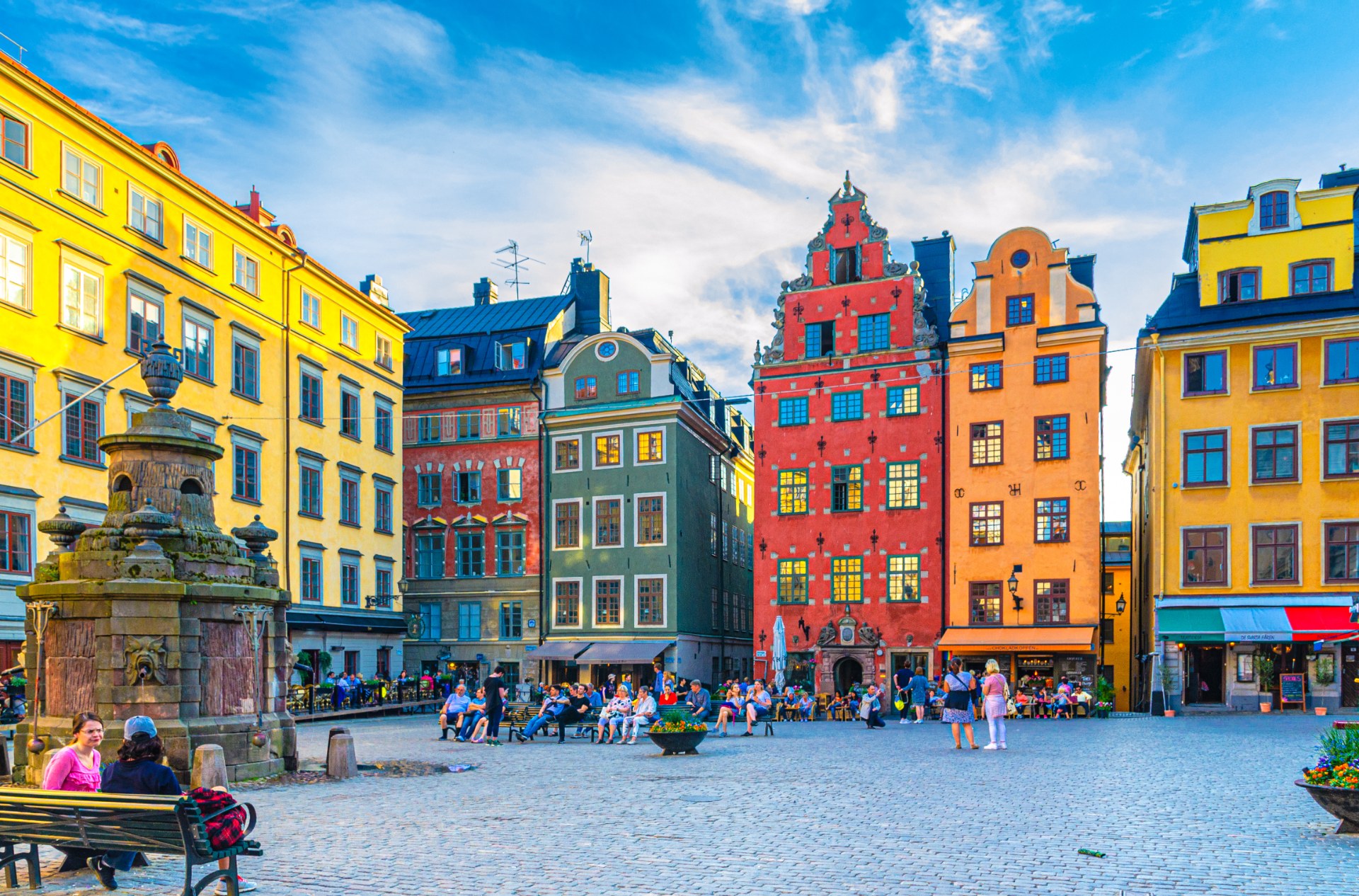 Turyści i przechodnie na placu Stortorget w Sztokholmie wśród kolorowych kamienic